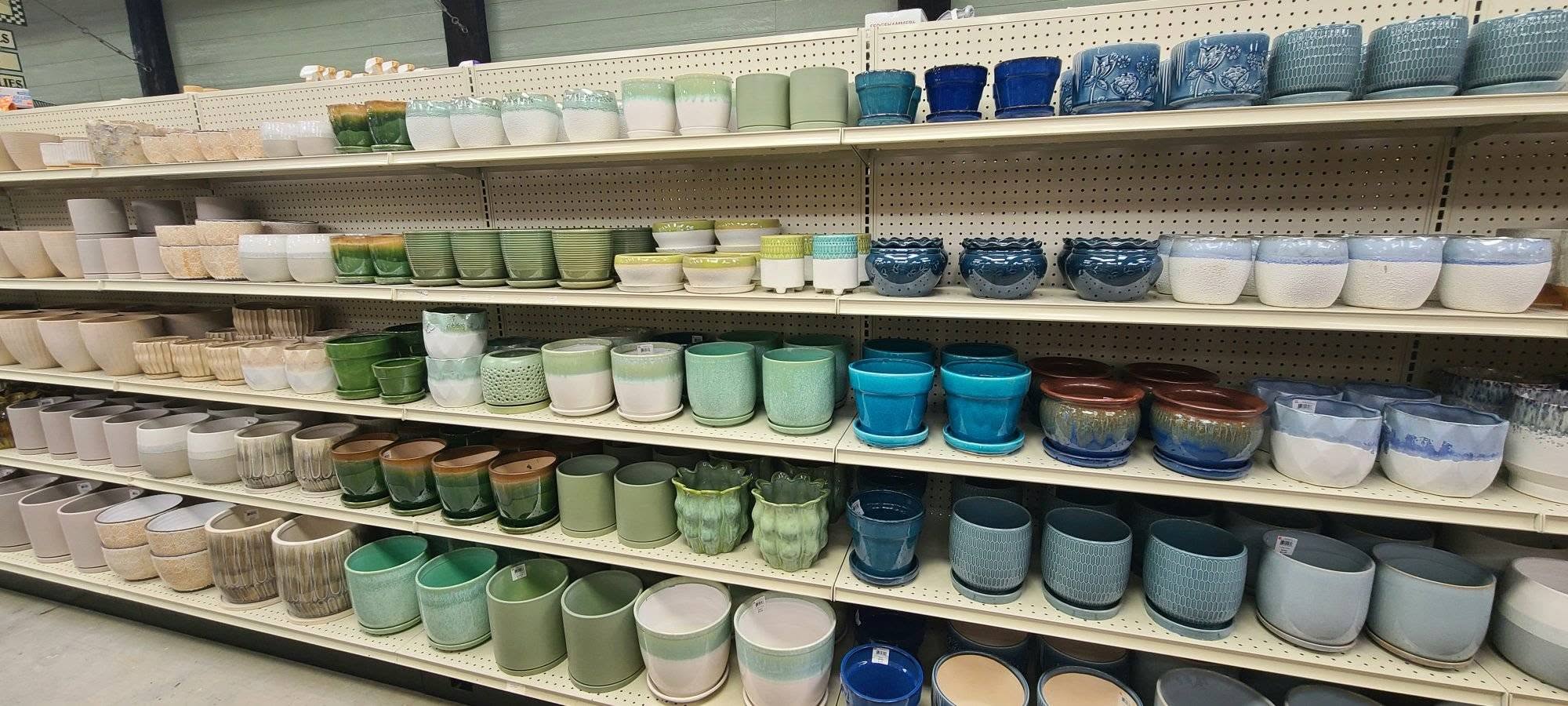 Shelving unit with various ceramic pots in different colors and sizes.